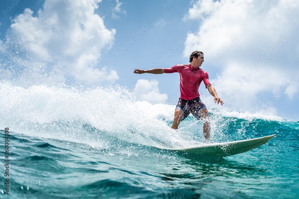 Surfer rides the wave at sunny day - obrazy, fototapety, plakaty 