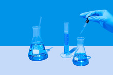 Chemistry Laboratory Research - Scientist Mixing Chemicals Using Test Tubes And Beakers 