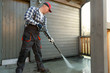 © artursfoto - Man is cleaning terrace with a high temperature pressure cleaner on concrete terrace floor