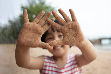 Wall Mural - Asian Chinese little girl playing sand at beach