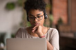 © fizkes - Focused african american girl student wearing headphones looking at laptop