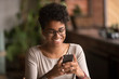 © fizkes - Happy millennial african american woman holding smartphone using ecommerce apps