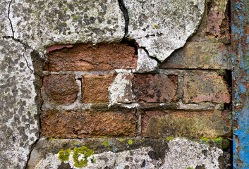 flaking and cracked render revealing brickwork on condemned derelict factory building awaiting demol