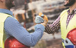 © Alessandro Biascioli - Young builders shaking hands making an agreement on construction site - Workers reaching a deal and on work project - Building, dealing, engineer industrial concept
