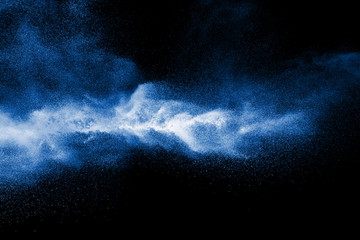 Splash of blue color powder dust on black background.