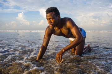 Wall Mural - young attractive and sexy black afro American man with athletic muscular body posing cool in sea water on desert beach in male beauty and plasticity concept