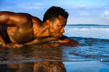 Wall Mural - young attractive and sexy black afro American man with athletic muscular body posing cool in sea water on desert beach in male beauty and plasticity concept