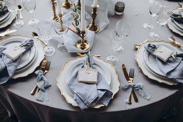 banquet table is decorated with plates, cutlery, glasses, candles and flower arrangements