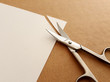 © Renars2014 - Cutting corners idiom Briticism hand takes sheet of paper and cutting corners by scissors doing something so easily and cheaply as possible