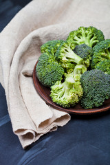 Canvas Print - Fresh green organic broccoli in brown plate and linen napkin