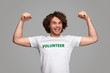 © kegfire - Cheerful volunteer flexing muscles