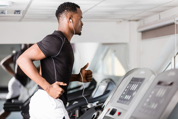 Wall Mural - Black African American  young man doing cardio workout at the gym