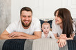 © o_lypa - Portrait of happy young smiling family in bedroom.