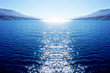 Abstract blue big dimension background with sea, sky and with white sun which enters the sea and leaves reflection on sea surface