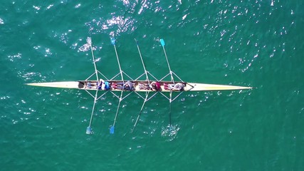 Wall Mural - Aerial drone bird's eye view video of yellow sport canoe operated by team of young team in emerald clear sea