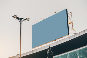 Wall Mural - An empty huge poster mockup on the roof of a shopping mall; blue solid template placeholder of an advert billboard on the rooftop of a modern building; blank mock-up of an outdoor information banner