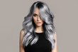 Leinwandbild Motiv Beautiful woman with long wavy coloring hair. Flat gray background.