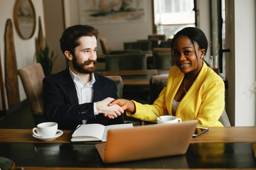 Sticker - Handsome man in a black suit. Woman in a yellow jacket. Businessman working in a office