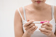 Unhappy young asian woman holding pregnancy test showing a negative result in her bathroom, wellness and healthy concept, infertility problem,Selective focus.
