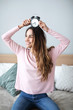 © BestForYou - Joyful woman with an alarm clock on her head at home.