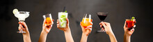 Hands Holding Classic Cocktails On Rustic Background