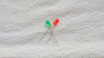 Wall Mural - Red and green LED lights resting on a white background