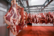Close up of a half cow chunks fresh hung and arranged in a row in a large, lights fridge in the fridge meat industry.