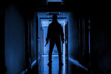 Murder, Kill And People Concept - Criminal Or Murderer Wearing A Mask In Silhouette Holding Knife Inside A Condo At Crime Scene.
