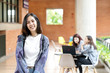 © ChayTee - Headshot of young happy attractive asian student smiling and looking at camera with friends on outdoor university background. Asian woman in self future education or personalized learning concept.