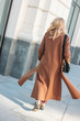 © Galina Zhigalova - Stylish fashionable woman wearing beige coat with curly blonde hair from back at street