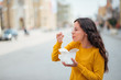 © bnenin - Girl enjoying take away food in the street.
