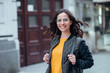 © bnenin - Smiling female tourist walking in the town street, looking at camera.
