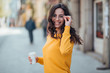 © bnenin - Portrait of a smiling woman walking in the city with take-away drink on a spring day.