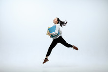 Getting faster and stronger. Happy woman working at office, jumping and dancing in casual clothes or suit isolated on white studio background. Business, start-up, working open-space concept.