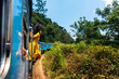 Woman enjoying train ride through Sri Lanka tea plantations