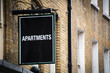 'Apartments' sign on side of brick building