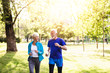 © hedgehog94 - Happy senior couple jogging outdoors in park.