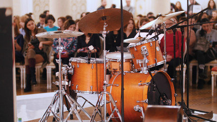 A jazz concert in the concert hall. Drum kit and audience on a background