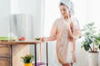 © LIGHTFIELD STUDIOS - Young woman in housecoat with towel on head in kitchen