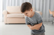 © New Africa - Little boy suffering from nausea in living room