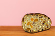 Bread with dried fruits and nuts on a cutting Board on a pink background