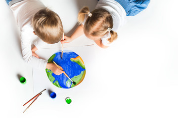 ecology concept with two prety little kids painting earth on white background