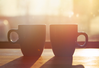 Wall Mural - two cups of coffee on wooden table in morning sunlight