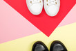 Black canvas shoes and white sneakers on colorful background. Flat lay