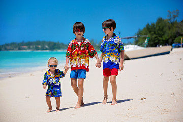 Canvas Print - Happy beautiful fashion children, dressed in hawaiian shirts, playing together on the beach