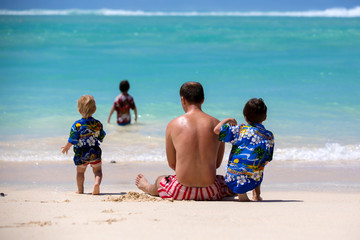 Sticker - Happy beautiful fashion family, mom and children, dressed in hawaiian shirts, playing together on the beach