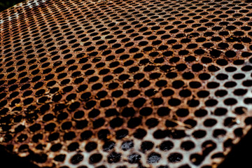 Poster - Perforated rusty iron texture. Surface with depth of field, abstract industrial mesh background