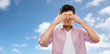 © Syda Productions - vision and people concept - man closing his eyes by hands over blue sky and clouds background