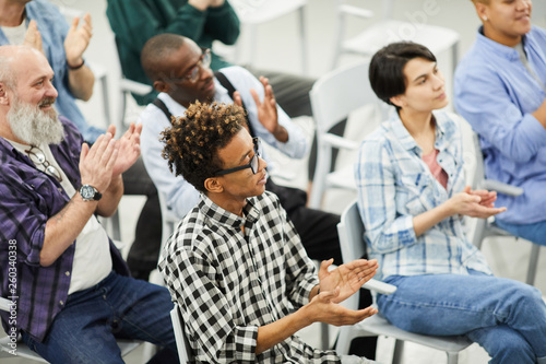Audience of educational forum: group of content multi-ethnic people sitting on c Wallpaper Mural