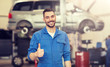 © Syda Productions - car service, repair, maintenance, gesture and people concept - happy smiling auto mechanic man or smith showing thumbs up at workshop